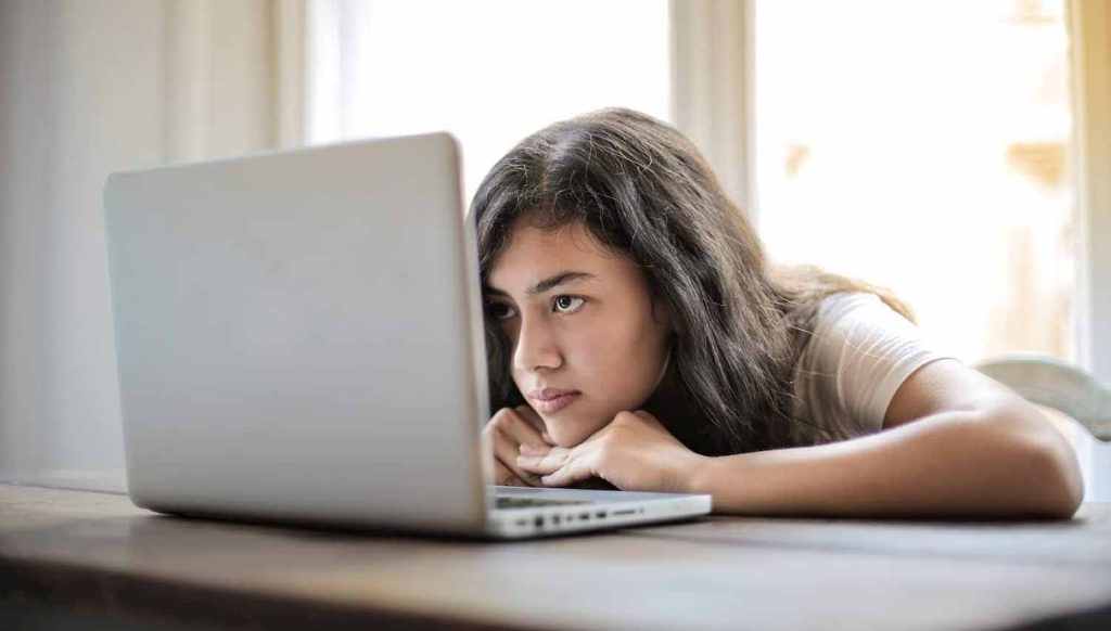 Woman focused on laptop screen, analyzing website content performance