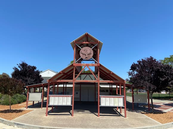 Historic wooden bell tower structure in Sunnyvale park under clear blue sky