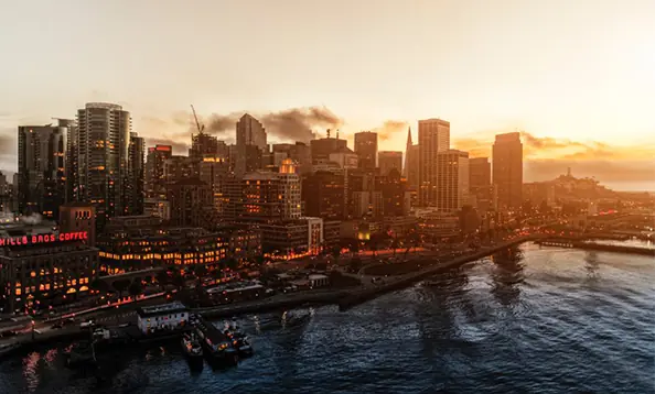 San Francisco skyline at sunset with illuminated buildings and waterfront