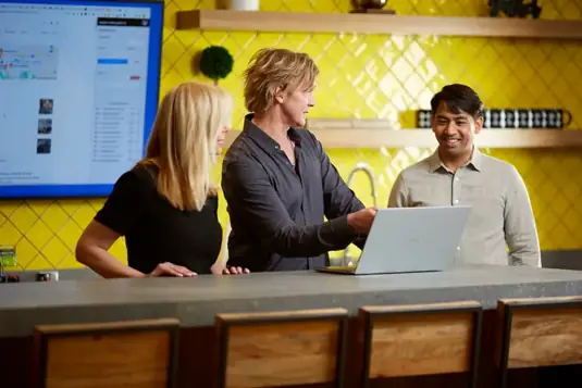 Team discussing digital marketing strategy at bright office workspace with laptop