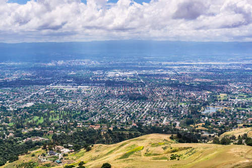 Aerial view of San Jose and surrounding Silicon Valley neighborhoods with hills and green valleys