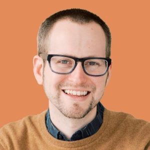 Brian Honigman, digital marketing professional, smiling against orange background