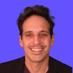 Man smiling at camera against purple background