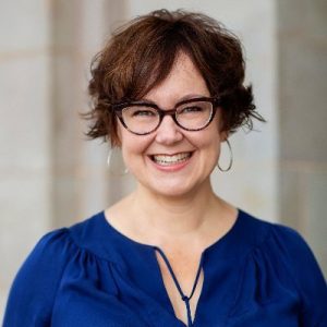 Kristina Halvorson smiling at camera, wearing glasses and blue blouse