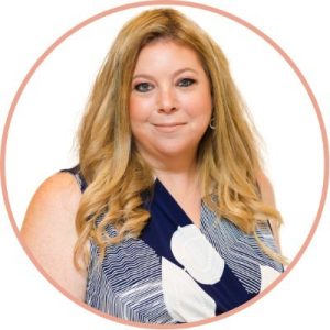 Lilach Bullock, digital marketing professional with long reddish-blonde hair, wearing navy and white patterned top in