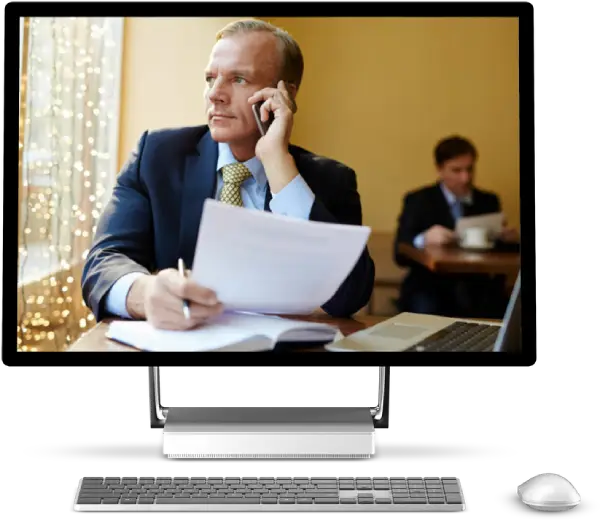 Business professional on phone call reviewing documents at desk with laptop