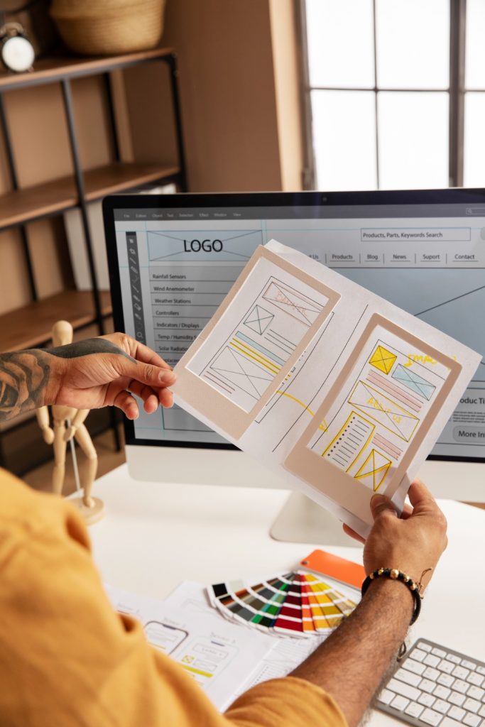 Designer reviewing website wireframe sketches and color palette