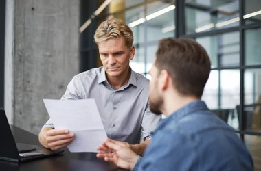 Two professionals reviewing digital marketing strategy document in modern office