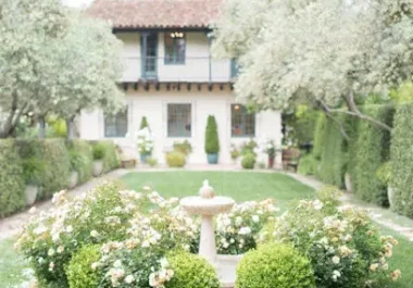 Elegant Mediterranean-style estate garden with fountain, manicured hedges, and flowering plants in Menlo Park