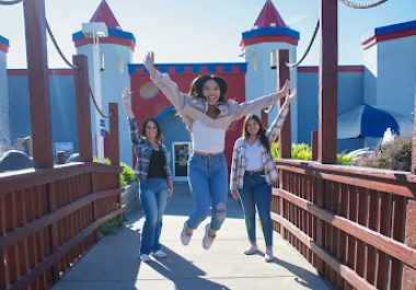 Family enjoying Livermore amusement park with castle-themed structures and flags