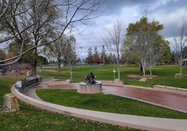 Cupertino Memorial Park with curved pathways, green lawn, and trees under cloudy sky