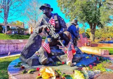 Cupertino Veterans Memorial with American flags and floral tributes in park setting