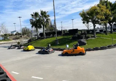Go-kart racing track with yellow, black, and orange karts at recreational facility