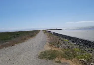 Gravel path along Hayward Regional Shoreline with bay waters and hills visible in distance