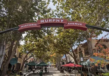 Historic Murphy Avenue street sign spanning tree-lined Sunnyvale street with shops and buildings