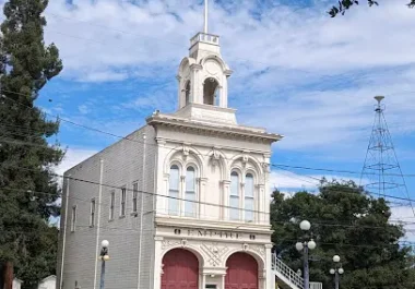 Historic white building with red doors and bell tower in San Jose, California