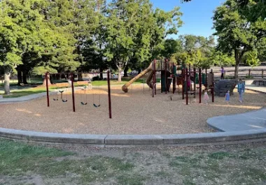Jollyman Park playground with equipment and shaded trees in Cupertino