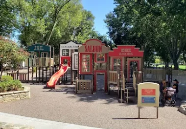 Osage Station Park playground with red saloon-themed structure and slide in Danville