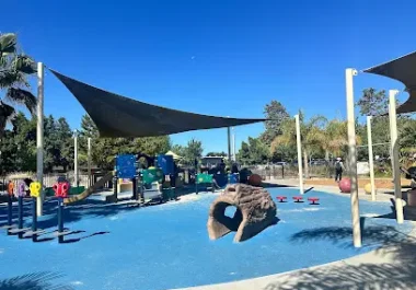 Seven Seas Park playground with blue surfacing and shade structures in Sunnyvale