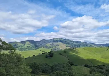 Rolling green hills and mountains under blue sky with white clouds, Shell Ridge Open Space, Walnut Creek CA