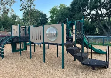 Playground with climbing structures and green slide at Stanford Hills Park, Menlo Park