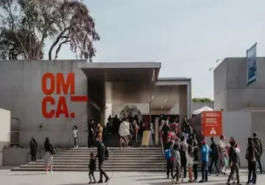 OMCA museum entrance with visitors gathered on steps in Oakland