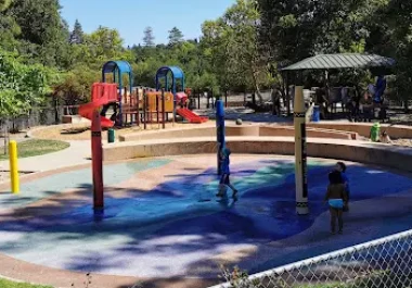 Colorful playground with red and blue climbing structures in Redwood City park