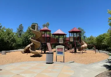 Large playground with castle-themed equipment and slides in Pleasanton community setting