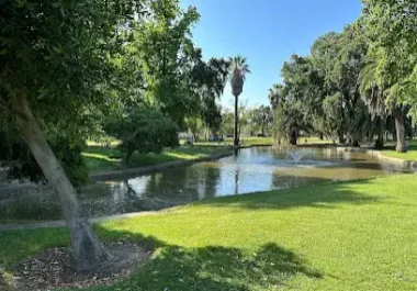 Scenic park with pond, mature trees, and green lawn in Stockton